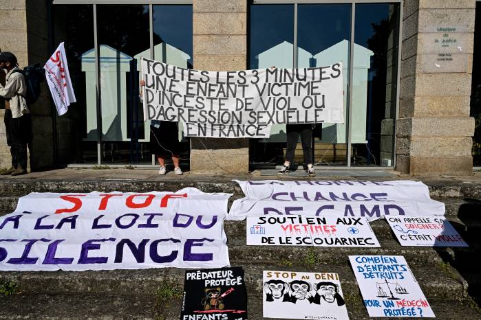 Manifestantes sostienen una pancarta que dice “Cada 3 minutos, un niño es víctima de incesto, violación o agresión sexual en Francia” durante una manifestación en apoyo a las víctimas del excirujano.