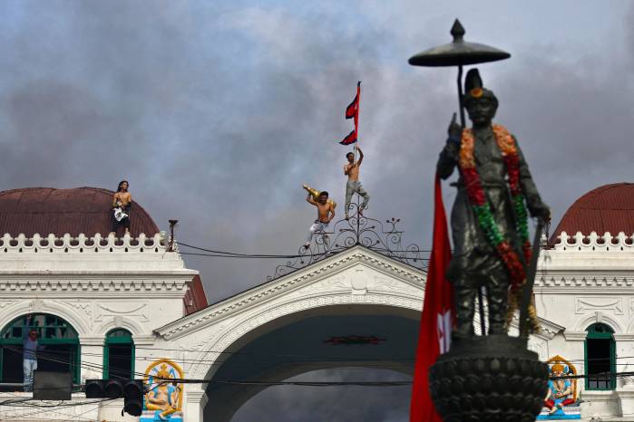 Manifestantes en la azotea del Singha Durbar, el principal edificio administrativo del gobierno de Nepal, en Katmandú el 9 de septiembre de 2025, un día después de la represión policial contra las manifestaciones por la prohibición de las redes sociales y la corrupción gubernamental.