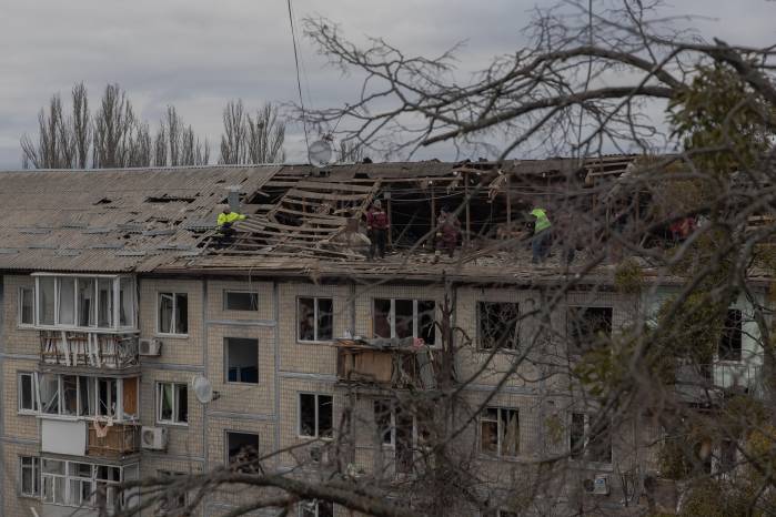 Trabajadores retiran escombros del techo de un edificio residencial gravemente dañado tras un ataque con drones en Kyiv, el 23 de diciembre de 2025, en medio de la invasión rusa de Ucrania.