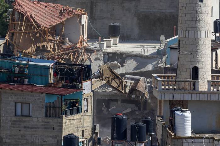 Una excavadora del ejército israelí demuele una casa palestina durante una redada en el campo de refugiados de Nur Shams, en Cisjordania ocupada, el 8 de mayo de 2025.