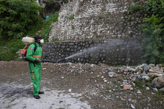 Un integrante de la Comisión Militar y Policial fumiga para eliminar criaderos del mosquito transmisor del dengue en Santo Domingo.