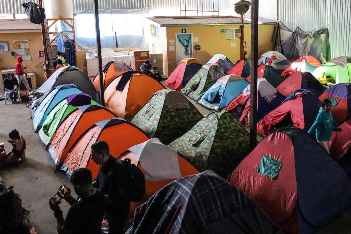 Migrantes descansan en tiendas de campaña en el albergue Juventud 2000, el 16 de diciembre de 2023, en la ciudad de Tijuana en Baja California (México).