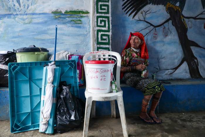 Mujer guna de la isla Gardí Sugdub esperando ser trasladada a tierra firme para llegar a su nueva hogar: la barrida Nuevo Cartí.