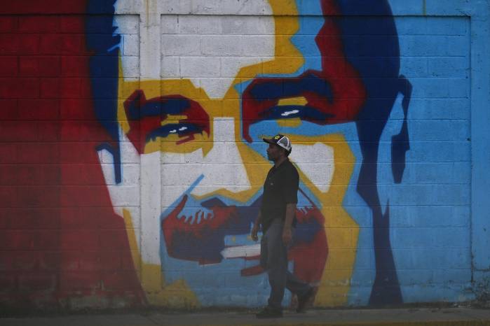 Un hombre camina junto a un grafiti que representa al presidente venezolano Nicolás Maduro en Caracas, el 3 de diciembre de 2026.