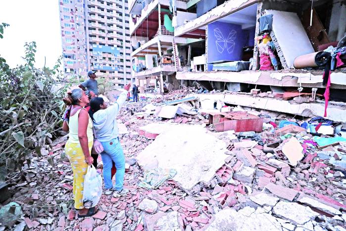 Residentes entre los escombros de uno de los bloques de viviendas dañados por los terremotos, en la localidad de Catia La Mar, en el estado costero de La Guaira (Venezuela) este jueves. EFE/ Ronald Pena R.