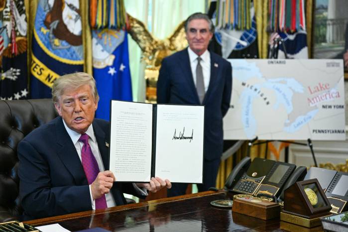 US President Donald Trump, alongside Secretary of the Interior Doug Burgum, displays an executive order he signed that aims to rename Lake Ontario to Lake America in the Oval Office of the White House in Washington, DC, on August 27, 2026. President Donald Trump announced Thursday that he is renaming Lake Ontario -- a large body of water shared by the United States and Canada -- Lake America. Trump signed an order in the White House, telling reporters the change was effective immediately. (Photo by Jim WATSON / AFP)