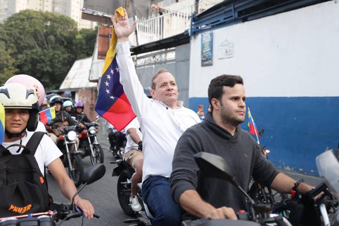 El opositor Juan Pablo Guanipa (c), cercano a la líder María Corina Machado, sostiene una bandera de Venezuela durante una caravana tras ser excarcelado este domingo, en Caracas (Venezuela). Guanipa abogó por la reconciliación en Venezuela, pero, subrayó, con la verdad, una declaración que hizo horas después de ser excarcelado luego de estar detenido desde mayo de 2025. EFE/ Ronald Peña R