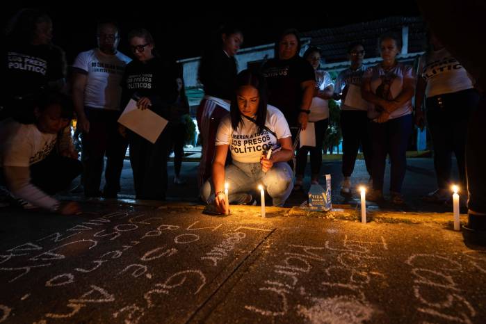 Una mujer prende una vela frente al centro penitenciario Rodeo I este viernes, en Zamora estado de Miranda (Venezuela). EFE/ Ronald Peña R