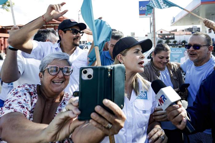 Fotografía de archivo que muestra a la candidata a la presidencia de Costa Rica Laura Fernández (c), saludando a simpatizantes en San José.