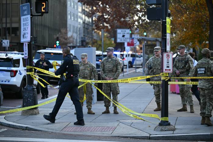 Soldados de la Guardia Nacional se reúnen cerca de una escena del crimen después de un tiroteo en el centro de Washington, D. C..