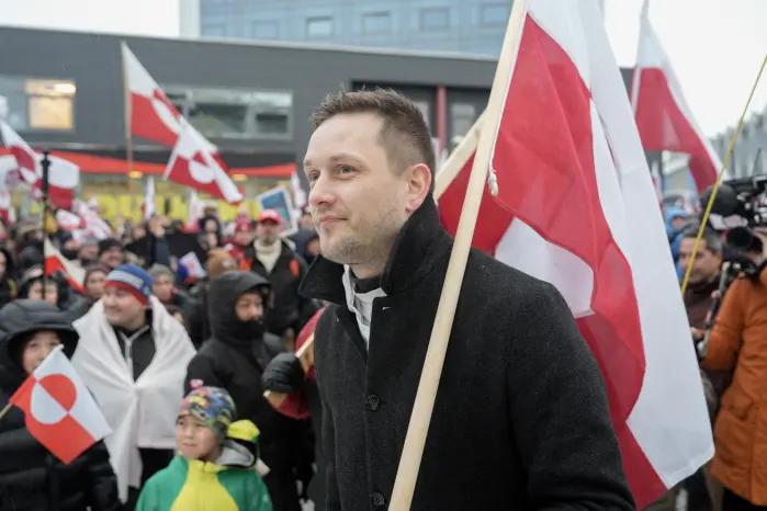 El jefe de Gobierno de Groenlandia (Naalakkersuisut), Jens-Frederik Nielsen, sostiene una bandera groenlandesa mientras participa en una manifestación frente al consulado de Estados Unidos en Nuuk, Groenlandia, el 17 de enero de 2026.