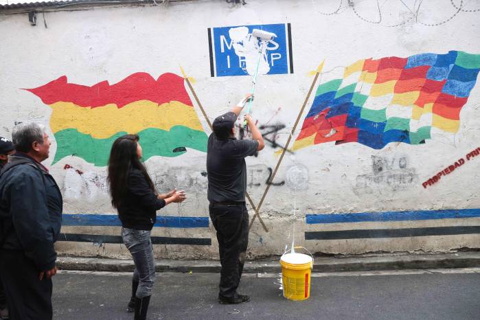 Fotografía del 10 de marzo de 2025 que muestra a una persona cubriendo el símbolo del partido Movimiento al Socialismo (MAS), en La Paz (Bolivia).