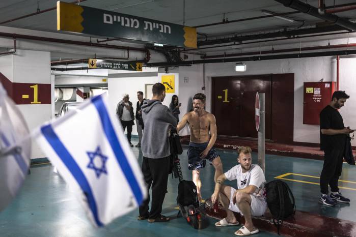 Bañistas esperan en un estacionamiento subterráneo utilizado como refugio antiaéreo cerca de la playa durante una alerta en Tel Aviv el 7 de marzo.