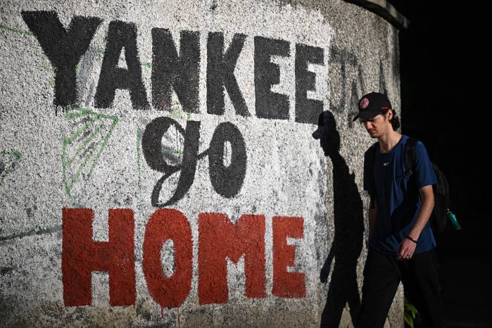 Un hombre pasa junto a un mural que dice “Yankee go home” en Caracas el 13 de noviembre de 2025.