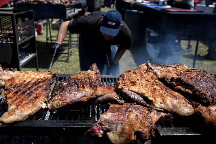 Un maestro parrillero acomoda el carbón mientras prepara la carne durante el festival ‘Locos por el asado’ en San Isidro.