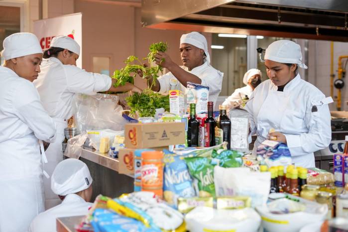 Los participantes seleccionan de las mesas de ingredientes los que utilizarán en sus platos.