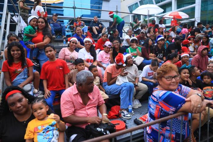 Familias disfrutan del desfile navideño.