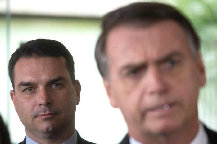 Foto de archivo de julio de 2018 del senador electo Flavio Bolsonaro (i), hijo del expresidente de Brasil, Jair Bolsonaro (d), escucha a su padre durante una rueda de prensa en Brasilia (Brasil).