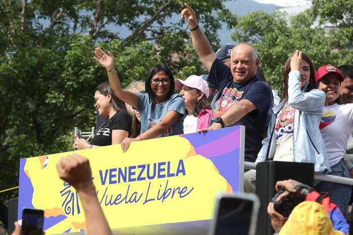 La presidenta encargada de Venezuela, Delcy Rodríguez, saluda junto al ministro de Interior y Justicia, Diosdado Cabello, durante una caravana este jueves, en Caracas (Venezuela).