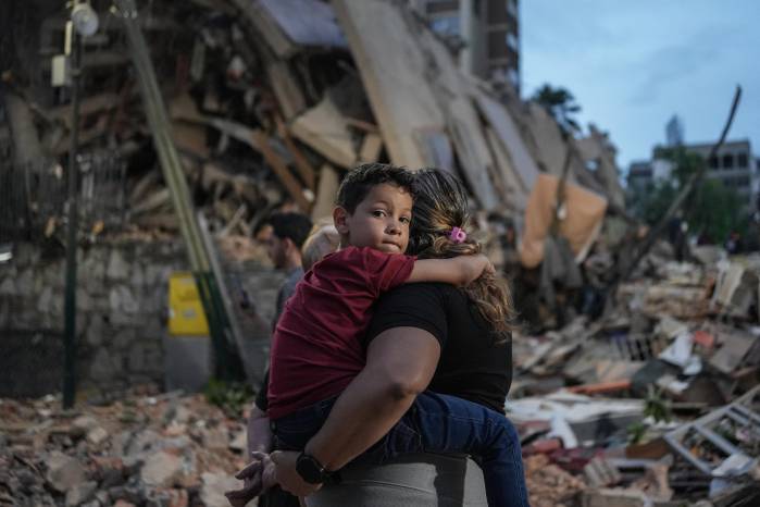 Varias personas caminan junto a un edificio derrumbado tras el terremoto que sacudió Caracas el 25 de junio de 2026.
