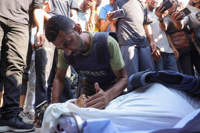 NOTA DE LOS EDITORES: Contenido gráfico / Un colega llora la muerte del periodista palestino Adam Abu Harbid, asesinado en ataques israelíes nocturnos, durante su funeral en el hospital Al-Shifa en la ciudad de Gaza el 25 de julio de 2025.