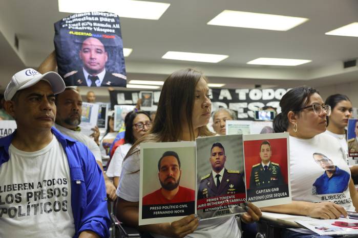Familiares de presos políticos sostienen carteles durante una rueda de prensa sobre la Ley de Amnistía este lunes, en Caracas (Venezuela).