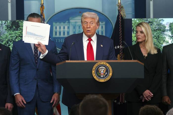 El presidente de EE.UU., Donald Trump (C), sostiene un documento mientras se dirige a los medios en la sala de prensa James S. Brady de la Casa Blanca, en Washington.
