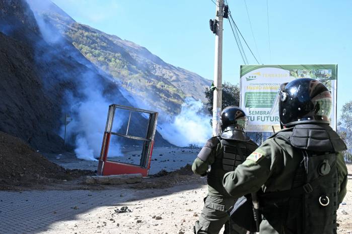 Agentes antidisturbios se enfrentan con manifestantes rurales en medio de gases lacrimógenos en Lipari, departamento de La Paz, Bolivia este 16 de mayo.