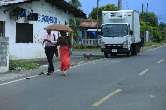 Personas caminan cerca de los vehículos debido al deterioro de aceras en Panamá.