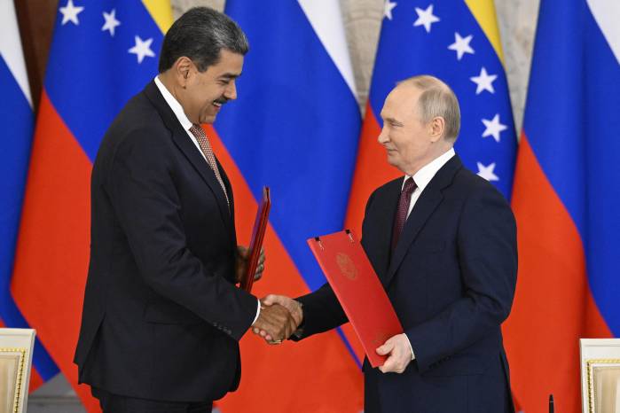 El presidente ruso, Vladimir Putin, y el presidente venezolano, Nicolás Maduro, se estrechan la mano mientras intercambian documentos durante una ceremonia de firma tras sus conversaciones en el Kremlin en Moscú el 7 de mayo de 2025.