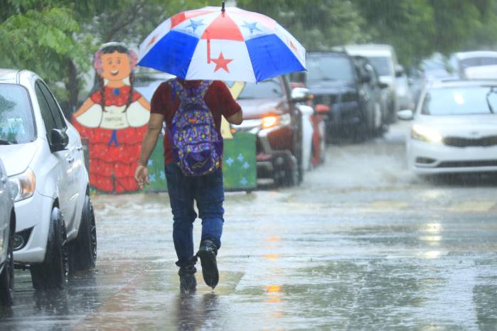 Panameño camina en medio de las fuertes lluvias en ciudad de Panamá.