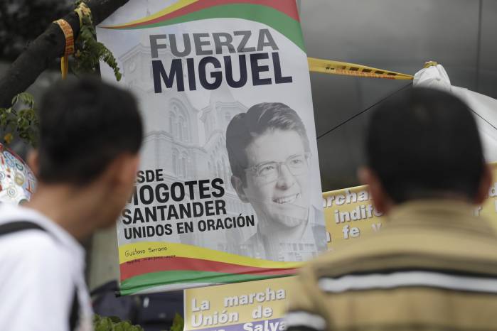 Fotografía de personas orando en un altar improvisado frente a la Fundación Santa Fe, lugar donde permanece hospitalizado el senador colombiano Miguel Uribe Turbay. EFE/ Carlos Ortega