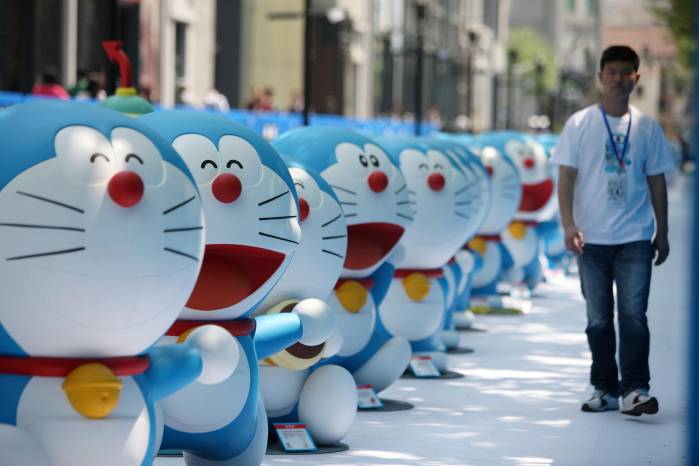 Imagen de archivo donde un empleado chino pasa junto a maquetas de Doraemon, un famoso personaje de dibujos animados japonés, en una exposición en Shanghái, China.