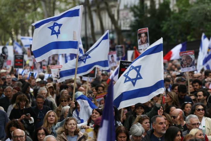 Manifestantes ondean banderas israelíes durante una marcha para pedir la liberación de los rehenes retenidos en el territorio de Gaza, en la ciudad de París.