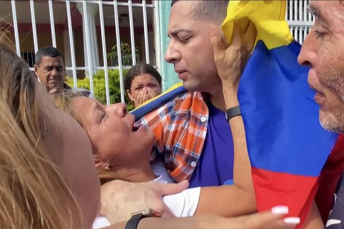 Esta instantánea de un video de AFPTV muestra a Maikel Olivera (centro), un migrante venezolano que fue liberado de la prisión salvadoreña, abrazando a su madre, Olivia Rojas, mientras se reúne con su familia en Barquisimeto, estado Lara, Venezuela.