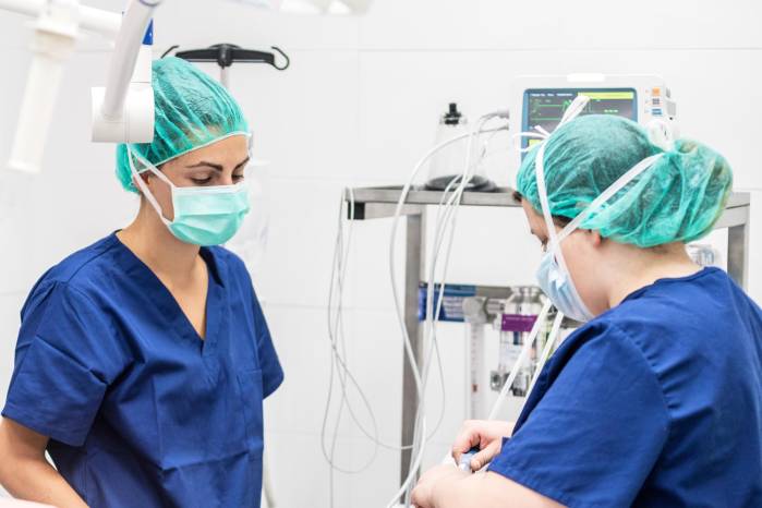 Covid-19 outbreak. Healthcare worker. Nurse working in intensive care unit. Mechanical ventilation system in the background .