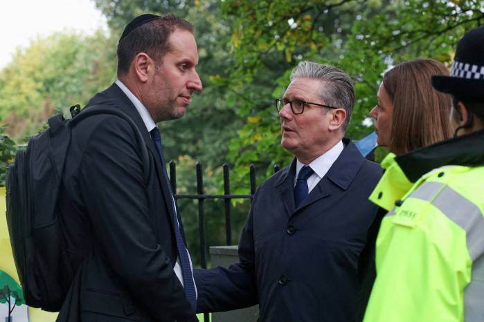 El primer ministro británico, Keir Starmer, y su esposa, Victoria, conversan con un miembro de la comunidad judía local durante su visita al lugar de los hechos.
