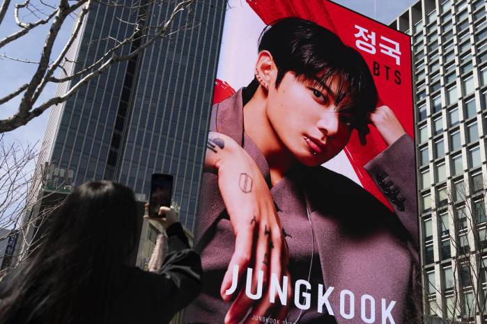 Un fan toma una foto cerca del escenario principal para un concierto gratuito del grupo de K-pop BTS en la Plaza Gwanghwamun en Seúl, Corea del Sur.