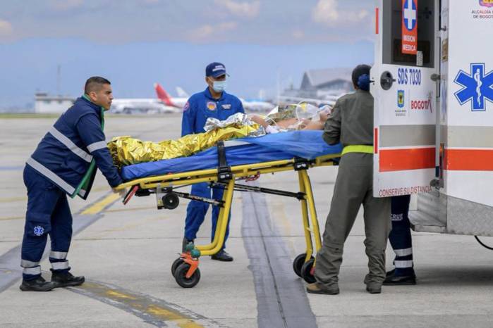 Miembros de la Fuerza Aeroespacial Colombiana y paramédicos transportan a una persona herida en la base aérea CATAM en Bogotá, Colombia, el 23 de marzo de 2026, tras el accidente del avión Hércules de la Fuerza Aérea ocurrido ese mismo día.