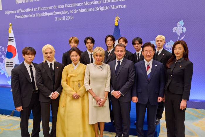 El presidente de Corea del Sur, Lee Jae-myung, y su esposa, junto al presidente de Francia, Emmanuel Macron, y la primera dama Brigitte Macron, posan con todos los integrantes del grupo Stray Kids durante el encuentro oficial en Seúl.