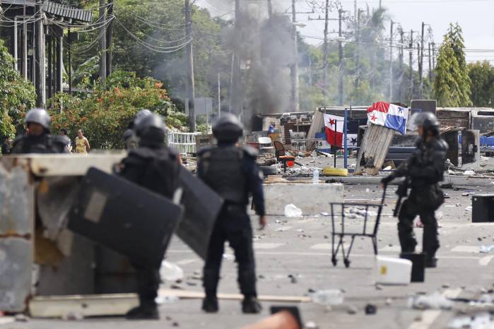 Fotografía que muestra a integrantes de la Unidad de Control de Multitudes que observan un bloqueo en una jornada de protestas en Changuinola, Bocas del Toro (Panamá).