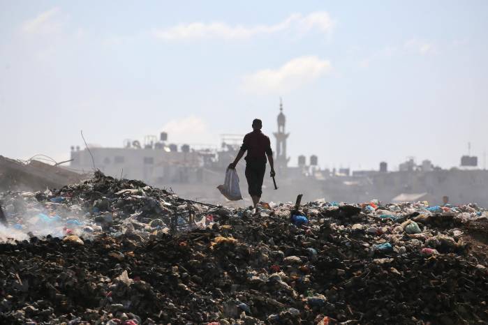 Un palestino busca objetos para rescatar en un vertedero de basura en el campamento de Al-Bureij, en el centro de la Franja de Gaza, el 7 de julio de 2025.