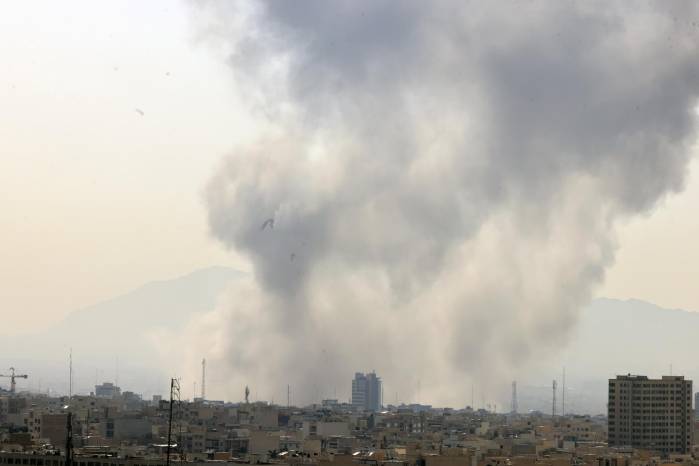 Una columna de humo emerge del centro de Teherán tras un ataque israelí este sábado.