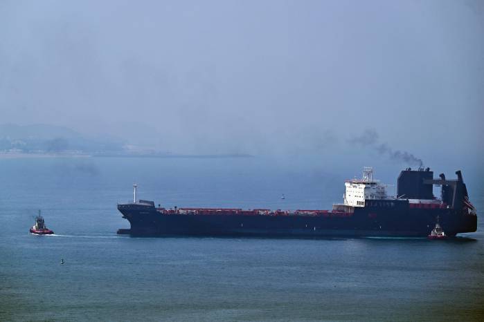Un remolcador guía a un buque en la Terminal de Contenedores de Khor Fakkan, el único puerto natural de aguas profundas de la región y uno de los principales puertos de contenedores del emirato de Sharjah, ubicado a orillas del Golfo de Omán.