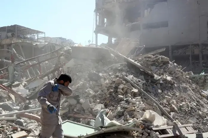 Un funcionario trabaja en un edificio dañado en los alrededores de la plaza Ferdowsi tras un ataque aéreo en el centro de Teherán, Irán, el 3 de marzo de 2026.
