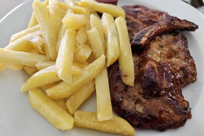 Chuletas BBQ con papas fritas.