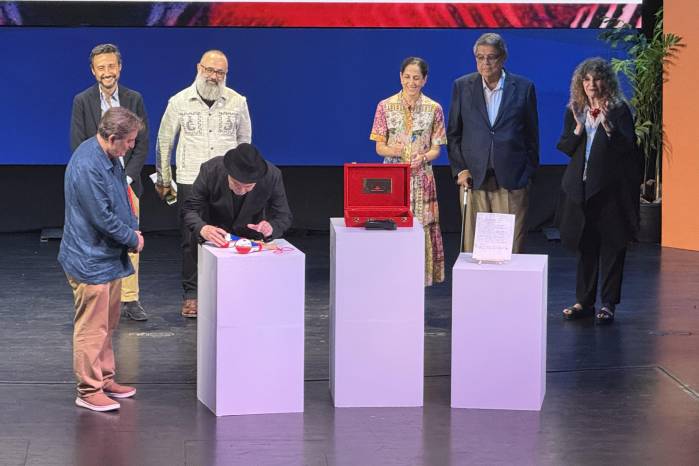 El presidente del Instituto Cervantes Luis García Montero acompaña a Rubén Blades mientras firma las maracas salseras que depositará en la Caja de las Letras.