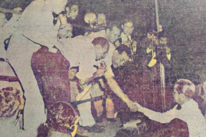 El campeón Louis (en el ring) saluda al presidente de la República, Enrique A. Jiménez, quien llegó al coliseo a presenciar el pleito.