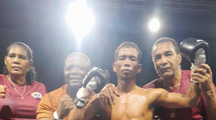 El púgil colombiano Héctor Alarcón luce la faja de campeón Fedecentro gallo de la Asociación Mundial de Boxeo (AMB).