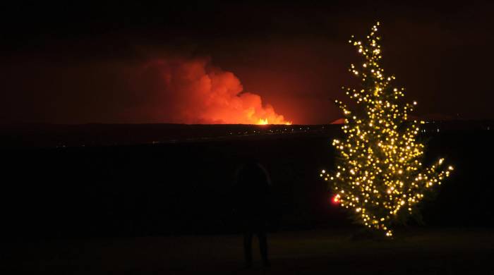Un árbol de Navidad luce mientras un volcán situado al suroeste de la capital de Islandia, Reikiavik, entra en erupción la madrugada del 19 de diciembre a unos 4 kilómetros al noreste de Grindavík.